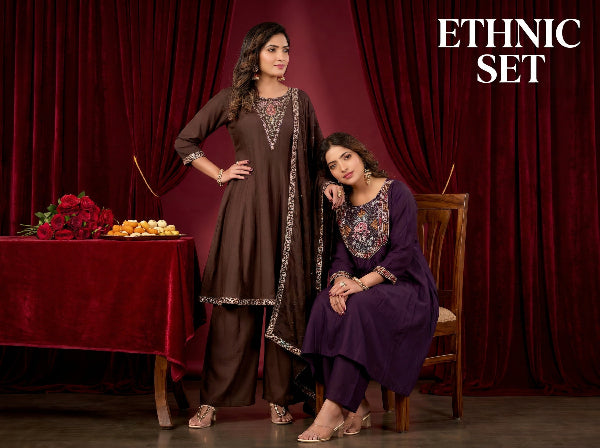 Two women in traditional outfits posing against a red curtain with 'ETHNIC SET' text.