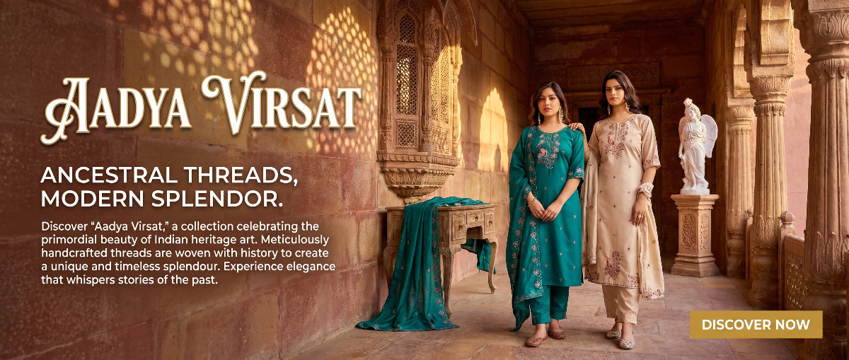 Two women in traditional attire standing in a grand architectural setting with 'Aadya Virsat' branding.